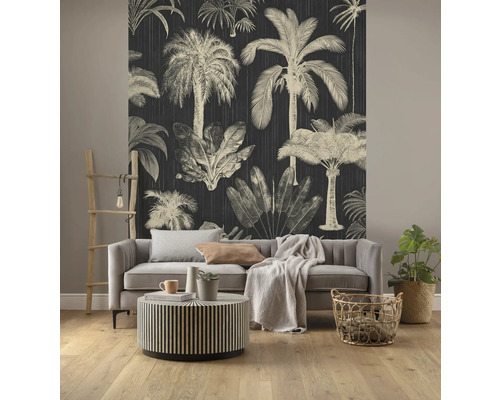 Woonkamer met donker behang met palmmotieven, bank en ronde tafel