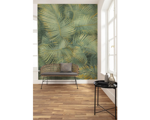 Woonkamer met palmbladerenbehang, bank en tafel