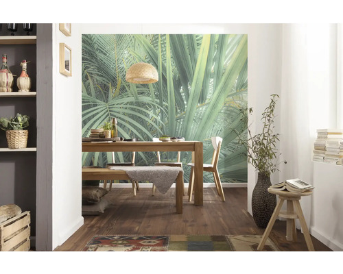 Eetkamer met houten tafel, stoelen en muurschildering met jungle thema