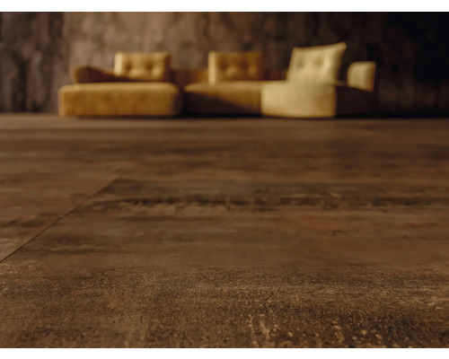 Close-up van donkerbruine vloerbedekking met bank op de achtergrond