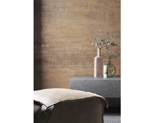 Kamerweergave met een poef, een bijzettafel en decoratieve objecten voor een gemusterde muur