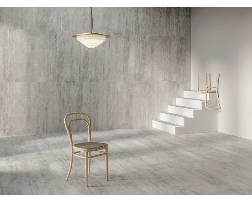 Interieur met grijs gemêleerde tegels, een hanglamp, een stoel en een trap