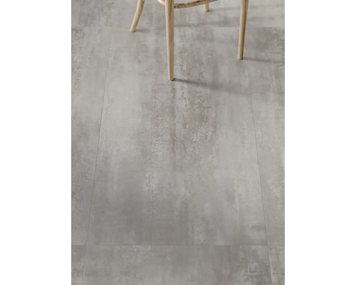 Tegelvloer met betonlook en stoelpoten op de voorgrond.