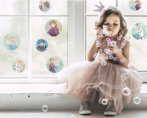 Meisje met kroon blaast bellen voor een raam met stickers van Frozen