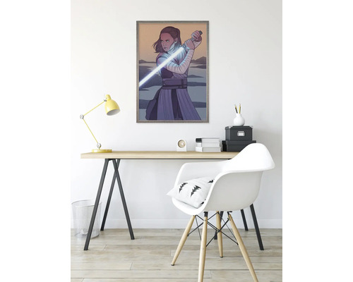 Ingelijste Star Wars poster met Rey en lichtzwaard op een bureau