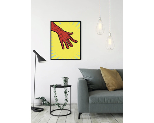 Woonkamer met bank, vloerlamp, bijzettafel met plant en een ingelijste afbeelding van een stripboekhand