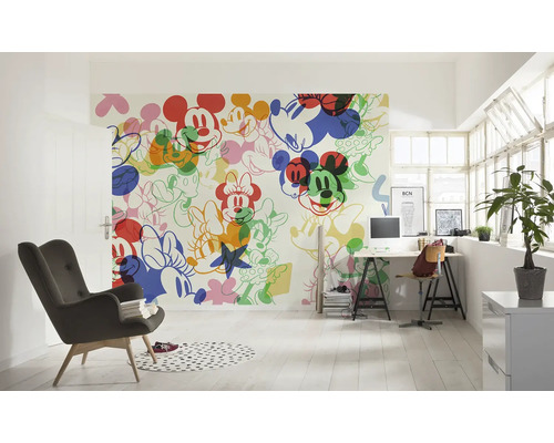 Lichte kamer met een wandbehang met Mickey Mouse motieven, een bureau en een fauteuil.