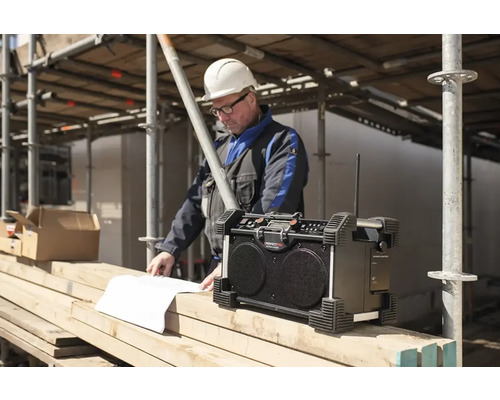 Bouwradio met bouwvakker die naar bouwtekeningen kijkt