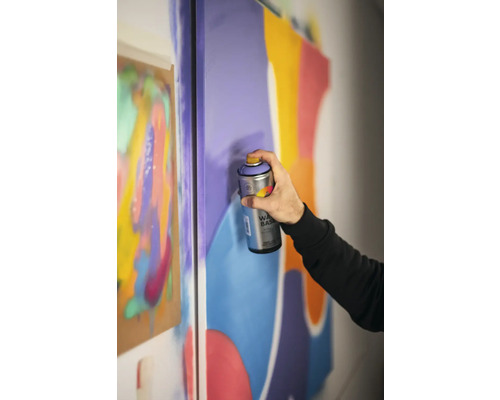 Iemand gebruikt spuitverf op een canvas voor kunstprojecten.