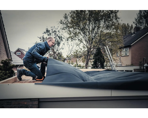 Ambachtsman legt dakbedekking op een plat dak