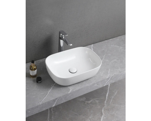 Opzetwastafel van keramiek met kraan op een werkblad