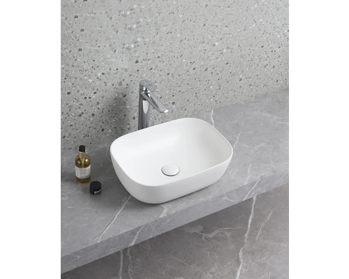 Keramische waskom op een plank met kraan