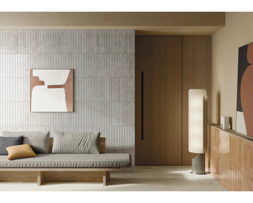 Woonkamer met betegelde wand, sofa en decoratieve verlichting voor een moderne sfeer.