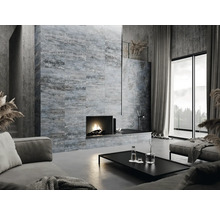 Woonkamer met bank, salontafel, open haard en wandtegels in modern design.