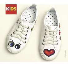 Paar witte sneakers voor kinderen met hart-, ster- en oogmotieven