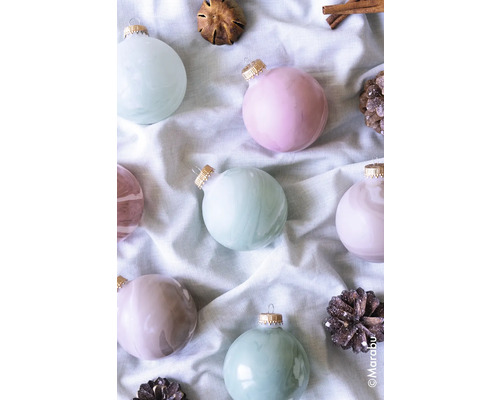 Decoratieve kerstballen met kaneelstokjes en dennenappels op stof