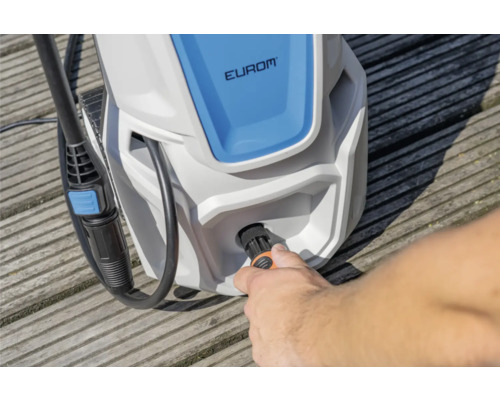 Een man sluit een slang aan op een Eurom hogedrukreiniger.