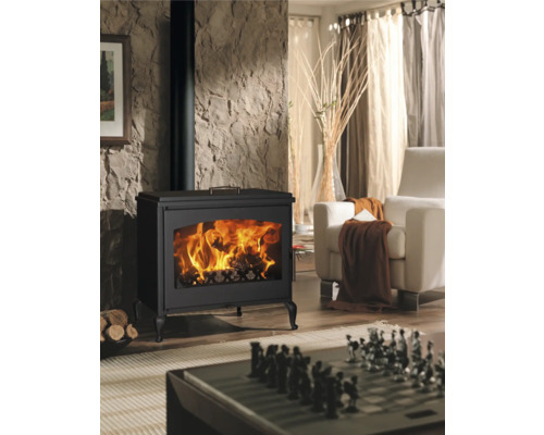Woonkamer met houtkachel, fauteuil en schaakbord op tafel