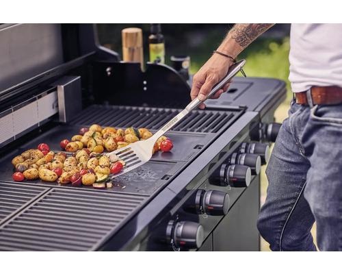 Groenten worden bereid op een barbecue met een barbecuespatel.