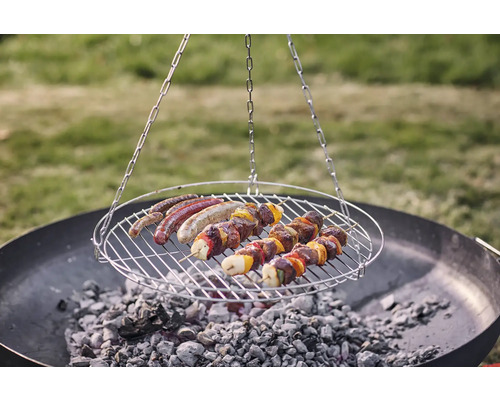 Draaibare barbecue met worstjes en vleesspiesen boven houtskool