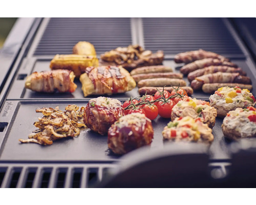 Diverse gerechten zoals worstjes, spek, tomaten en gevulde champignons op een grill.