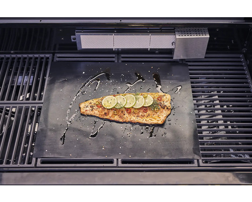 Zalm op grillmat met citroenpartjes en kruiden in de grill.