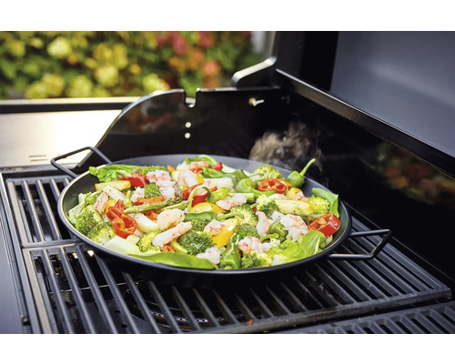 Groenten en garnalen in een grillpan op een barbecue