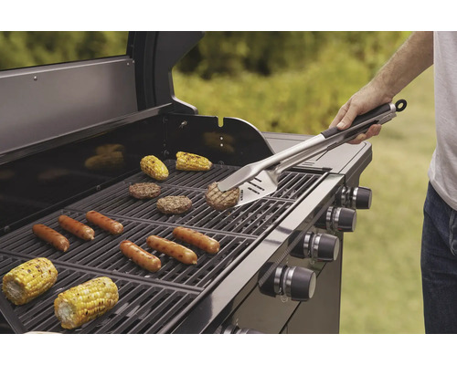 Barbecue met gegrilde worstjes, hamburgers en maïskolven, bediend met barbecuegereedschap