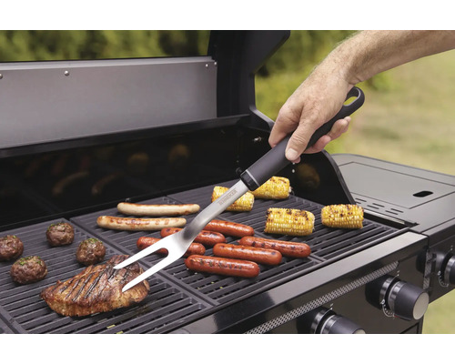 Persoon gebruikt een barbecuevork op een barbecue met verschillende voedingsmiddelen.