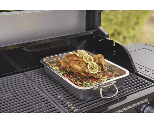 Gegrilde kip met groenten in een roestvrijstalen bak op een barbecue.