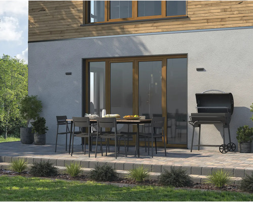 Buitenscène met tuintafel, stoelen en barbecue op een betegeld terras