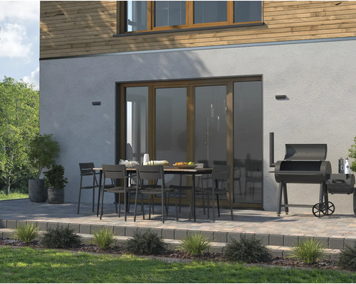 Buitenscène met terras, tuintafel, stoelen en barbecue voor ontspannen uren buiten.