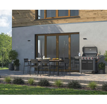 Terras met tuingrill, tafel en stoelen voor een huismuur