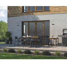 Terras met eettafel, stoelen, barbecue en barbecuekar voor een huis