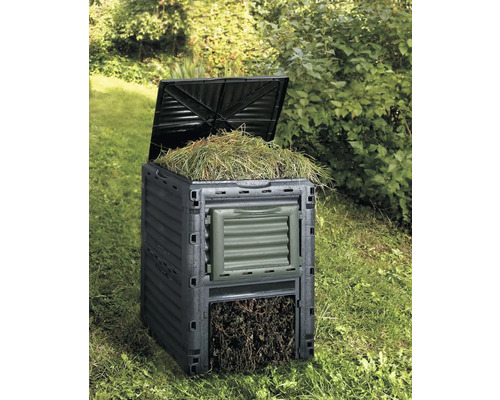 Compostbak met open deksel in de tuin