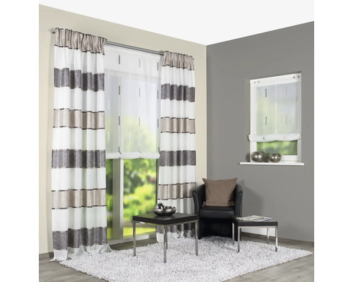 Woonkamer met gestreepte gordijnen, rolgordijn en fauteuil op een tapijt