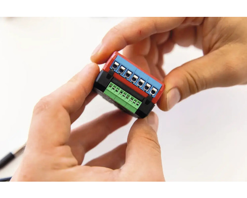 Handen houden een elektronisch onderdeel met aansluitklemmen vast