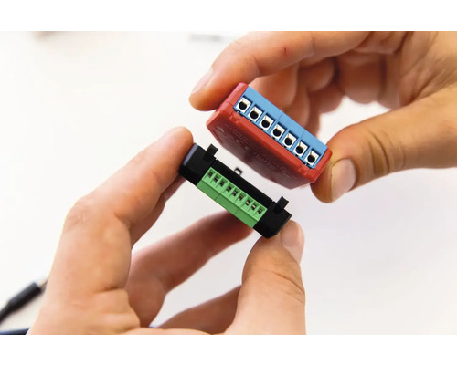 Twee connectoren worden vastgehouden door handen.