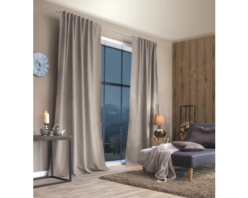 Woonkamer met ramen en gordijnen, evenals een bank en decoratie