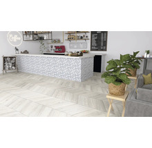 Interieurfoto van een café met een houten vloer in visgraatmotief, een toonbank met tegelpatroon en kamerplanten