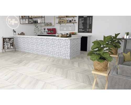 Interieurfoto van een café met een houten vloer in visgraatmotief, een toonbank met tegelpatroon en kamerplanten