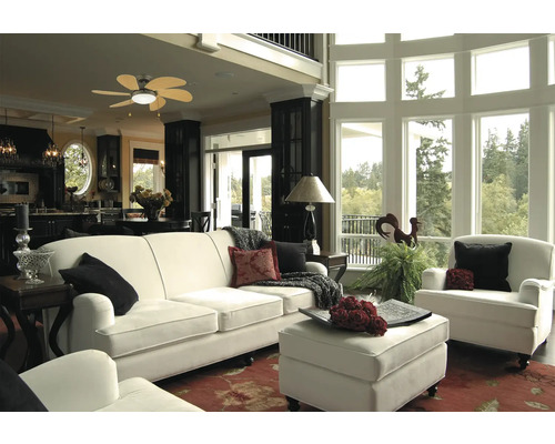 Lichte woonkamer met bank, fauteuil, voetenbank en groot raam