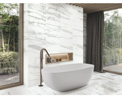 Moderne badkamer met vrijstaand bad, kraan en marmeren tegels.