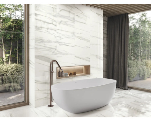 Badkamer met bad, kraan en wandtegels in marmerlook