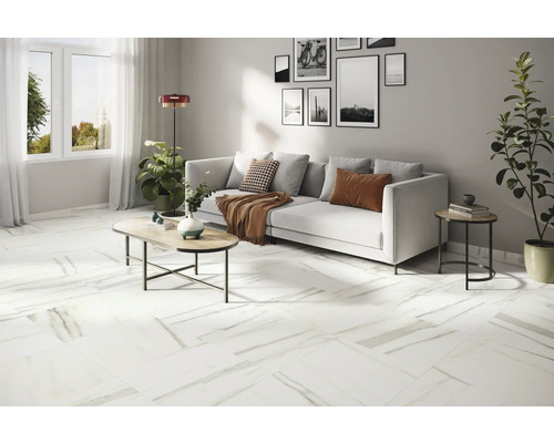 Lichte woonkamer met tegelvloer in marmerlook, bank, tafel en decoratie