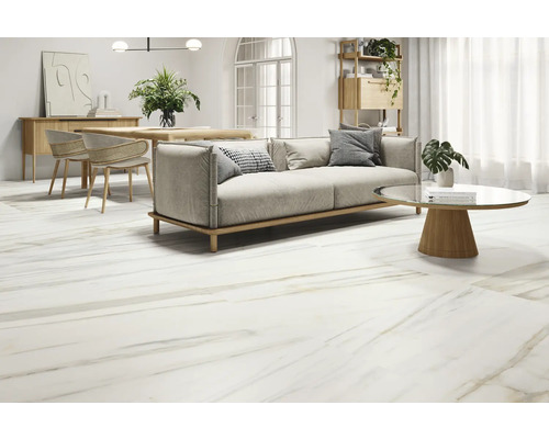 Lichte woonkamer met marmerlook vloertegels, bank, tafel en stoelen.