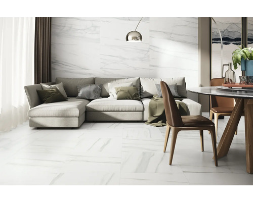 Lichte woonkamer met marmerlook tegelvloer, bank en eethoek