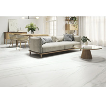 Woonkamer met bank, tafel en vloertegels in marmerlook.