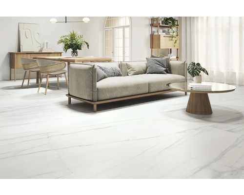 Woonkamer met bank, tafel en vloertegels in marmerlook.