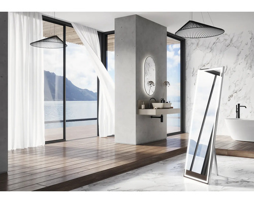 Badkamer met vrijstaande spiegel, wastafel, bad en uitzicht op zee